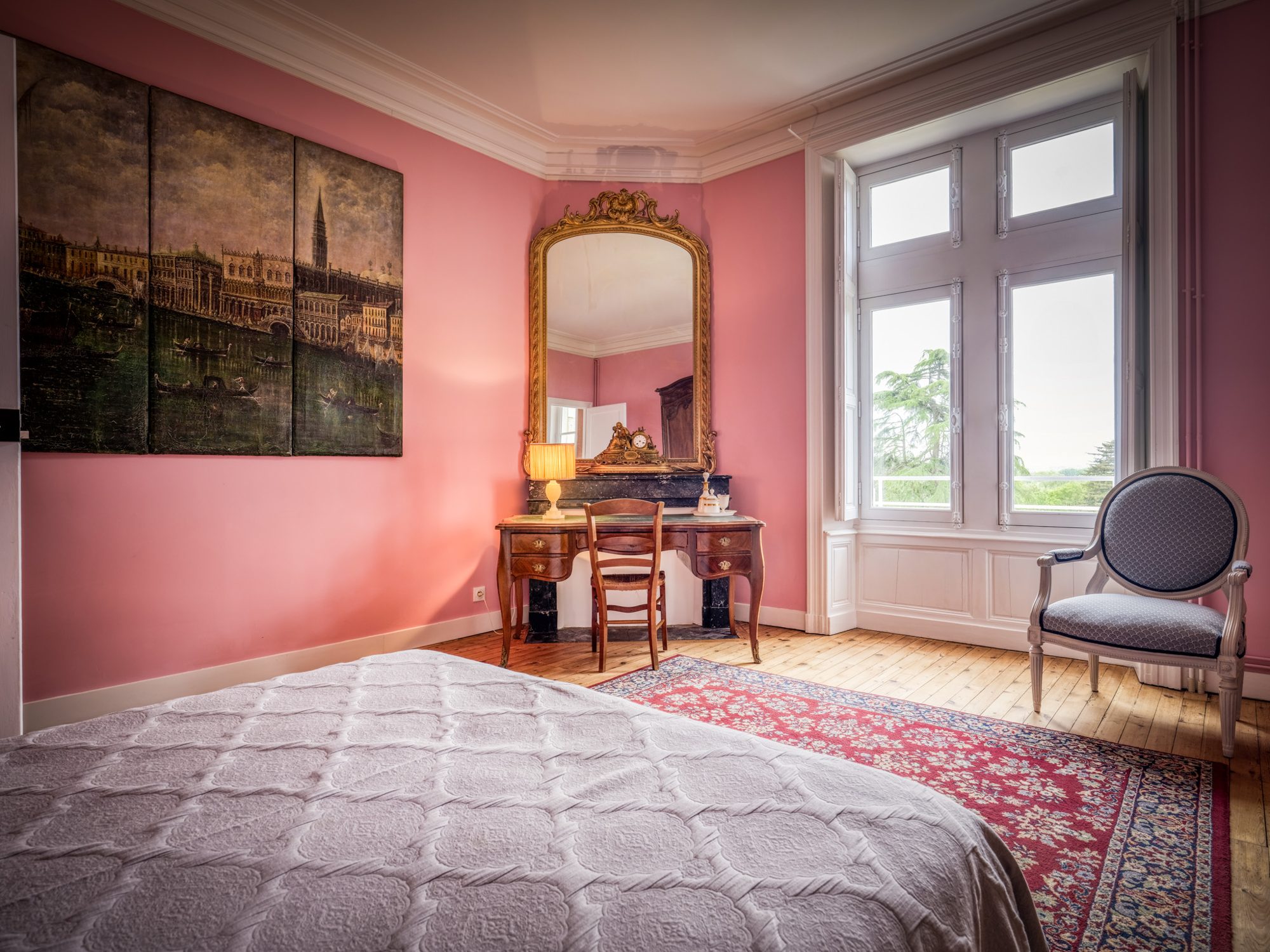 Chambre rose avec coiffeuse ancienne et miroir doré